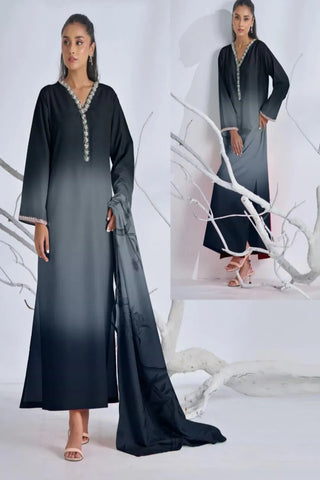 Woman wearing a black abaya with intricate detailing in a white room.